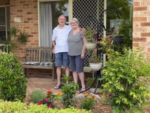 Photograph of Diane and Dave Merchant in front of their new home at Tarragal Glen