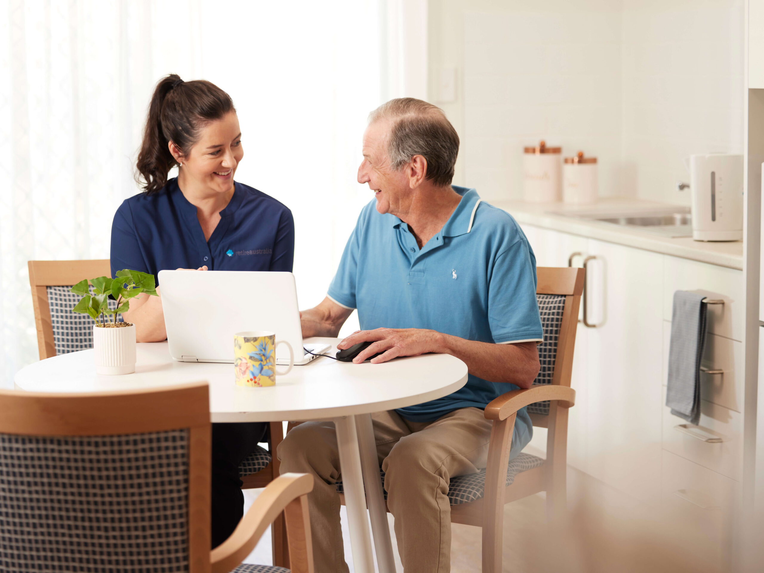 Resident and Retireaustralia Employee discussing next steps together at a dining table