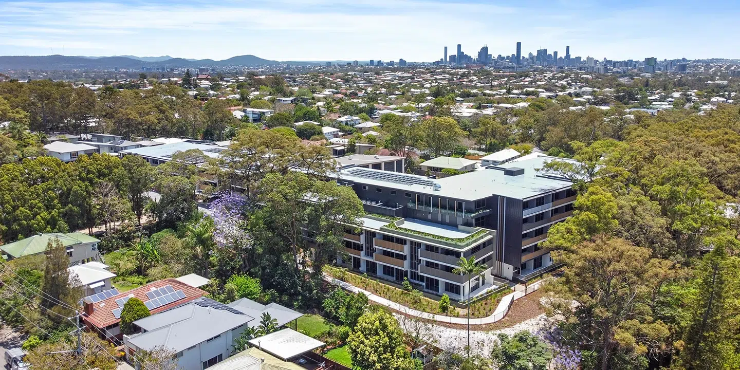 View of The Green retirement village nestled in the bushland with skyline of the Brisbane CBD