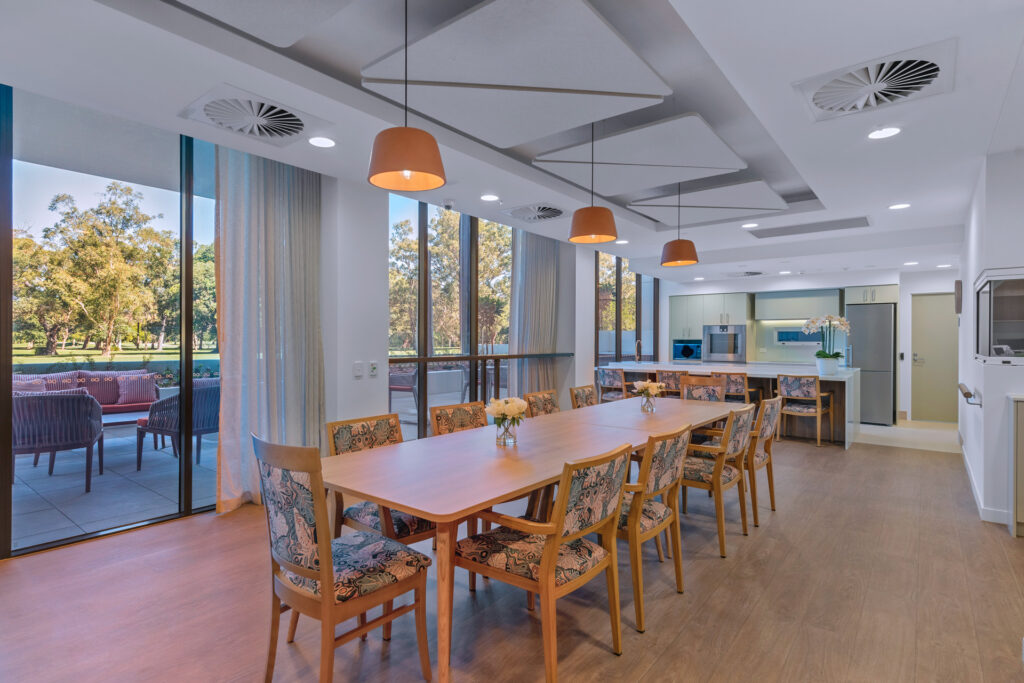 Dining hall, featuring long tables with chairs to enjoy a nice meal.