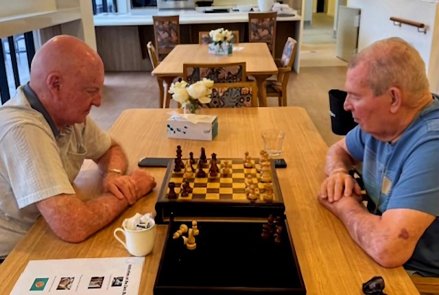 Care hub resident Dace enjoying a game of chess with friend.